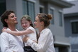 © ultramansk - Young couple with their laughing daughter hold their child close pointing out their future house outdoors on the street of a newly built residential neighborhood with copy space