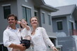 © ultramansk - Happy young family with little daughter embrace the girl and admire the freshly built homes among modern new houses of a suburban housing estate in warm natural light