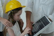 © ultramansk - Caucasian family of three with a small photovoltaic module guide their daughter's hand across the solar module surface in the bright interior of their newly built home