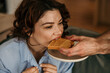 © La Famiglia - Woman biting peanut butter toast offered by partner