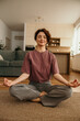 © La Famiglia - Woman meditating at home finding inner peace and wellness