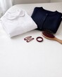 © Liora Stone visuals - Folded school uniform with hairbrush and hair accessories on white surface