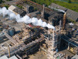 © Amazing Aerial - Aerial view of the Tronox chemical production factory with a prominent chimney emitting a smoke plume over industrial infrastructure in Stallingborough, England, United Kingdom.