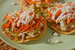 © AndreaGabriela - Mexican tostadas de tinga de pollo with fresh lettuce, sour cream, and cotija cheese. Direct flash