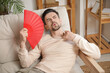 © Pixel-Shot - Handsome young man with fan on sofa at home