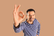 © Pixel-Shot - Handsome man showing OK on brown background