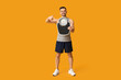 © Pixel-Shot - Handsome sporty young man pointing at scales on yellow background. Weight loss concept