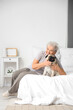 © Pixel-Shot - Senior woman with pug dog in bedroom