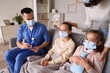 © Pixel-Shot - Doctor with ill little girls and mother in medical masks at home