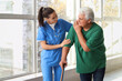 © Pixel-Shot - Nurse helping senior man with stick to walk at hospital