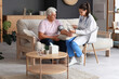 © Pixel-Shot - Young nurse measuring blood pressure of senior man at home