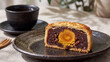© Harry - Traditional mooncake with red bean paste and salted egg yolk, served with a cup of tea.