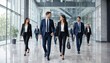 © MDABDUL - Corporate Ambition: A diverse team of business professionals walks confidently through a modern, sunlit office lobby, exuding professionalism and ambition.