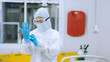 © vittaya - Healthcare Worker Adjusting Blue Rubber Gloves Wearing Full PPE Suit and Goggles for Infection Control Concept