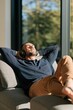 © Andrii Zastrozhnov - Relaxed man listening to music with headphones on sofa in sunlight for lifestyle background and wellness banner design