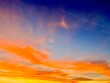 © GILPEDRO - Cielo espectacular durante el atardecer con nubes teñidas de intensos colores naranjas, amarillos y azules
