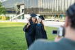 © Cata - Diverse women graduates celebrating academic achievement on campus while friend records graduation memories