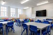 © oksa_studio - Class room interior with modern school tables and blue chairs for academic learning
