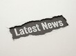 © andi - Torn Paper Revealing Latest News Text on Dark Background.