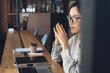 © tippapatt - Focused business woman thinking during working on laptop with notebook on table at cafe modern workspace. Student studying online, business planning, e-learning concept