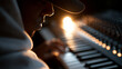 © Nick Freund - Musiker im Profil spielt Klaviatur im warmen Gegenlicht des Studios