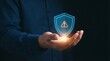 © Aliza - Hand reaches out to display a floating holographic security shield with a warning symbol for digital threats.