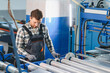 © Serhii - Worker wearing safety glasses operating plastic bag production machine