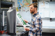 © Serhii - Printing press operator checking print quality in workshop