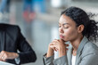 © BESTIMAGE - Stressed young businesswoman holding head working project about problem on laptop and documents during intense office discussion in business meeting with colleague deadline pressure.