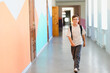 © Serhii - Smiling pupil walking in school corridor during break time