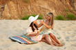 © Vagengeim - Mother Adjusting Daughter’s Sun Hat In Sandy Landscape