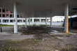 © Philip - Disused petrol station forecourt with weathered canopy overgrown paving and rusting support column