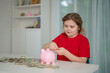 © Volodymyr - Counting money supports budgeting and finance. Smart kid counts dollars beside child. Happy child studies future money planning. Young kid supports savings growth.