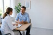 © Kate - Doctor consulting with male patient in a bright medical office