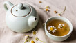 © Daniil - Ceramic teapot and herbal tea with chamomile on linen
