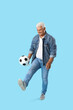 © Pixel-Shot - Mature man playing with soccer ball on blue background