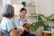© Natee Meepian - Asian female doctor consulting senior woman patient during home visit checkup