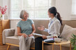 © Natee Meepian - Senior Asian woman consulting with nurse at home for healthcare checkup