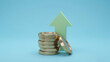 © MUKTA - Financial concept featuring a stack of coins and a green rising arrow, business