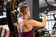 © Westend61 - Woman does upper body strength training on a gym machine indoors