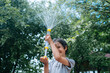 © TrueShot | Westend61 - Happy boy plays with a water gun outdoors in summer