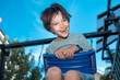 © TrueShot | Westend61 - A happy boy enjoys a swing at the outdoor playground