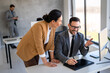 © NDABCREATIVITY - Two happy diverse multiethnic business team people working, talking in corporate office