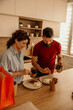 © La Famiglia - Couple enjoying takeaway meal with chopsticks at home