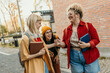 © La Famiglia - Happy students walking and laughing together on campus