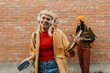 © La Famiglia - Happy student listening to music smiling outdoors