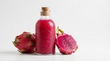 Vibrant pink dragon fruit juice in glass bottle with fresh fruit slices