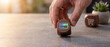 © Mrs. Taimoor - Hand holding a wooden cube with a glowing credit card icon, representing online payment and digital commerce concepts