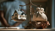 © pattozher - Weighing the Dream: A detailed miniature house is balanced against a sack of money on a vintage scale, symbolizing the significant decision of property investment and its financial implications.