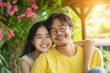 © SEcho - Young asian couple embracing affectionately near blooming pink flowers in a sunlit garden setting